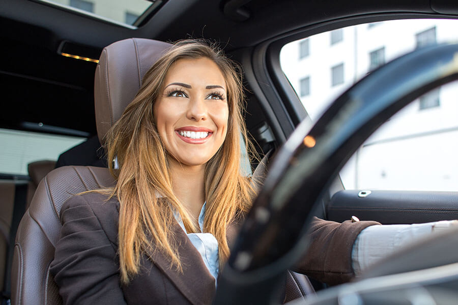 woman driving car smiling because she is a mobile notary